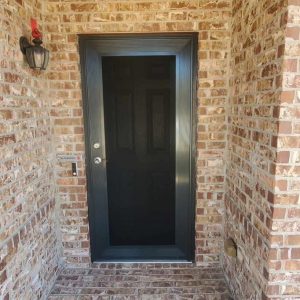 Bronze single front entry security screen door on brick porch in Arlington TX by Security Screen Masters of Texas