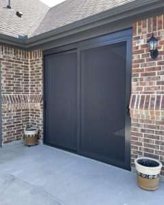 Custom bronze sliding patio security screen door installed on brick home in Dallas TX by Security Screen Masters of Texas