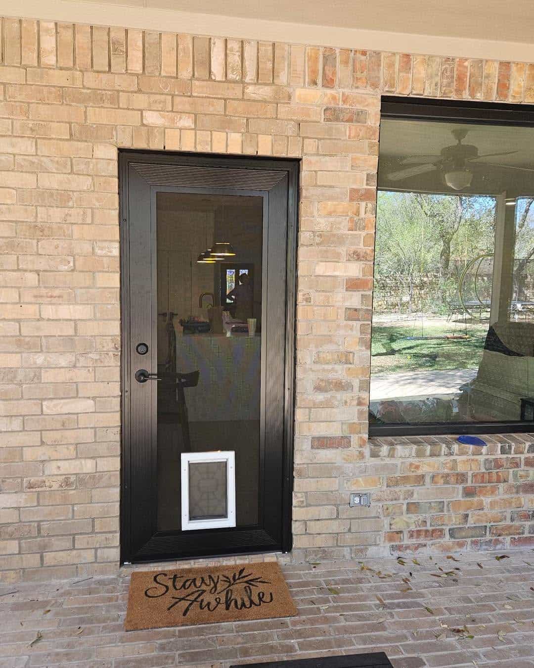 Heavy-duty front entry security screen door with built-in pet flap installed by Security Screen Masters of Texas