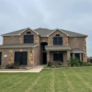 Two-story Texas brick home equipped with custom black security window screens in Southlake TX by Security Screen Masters of Texas