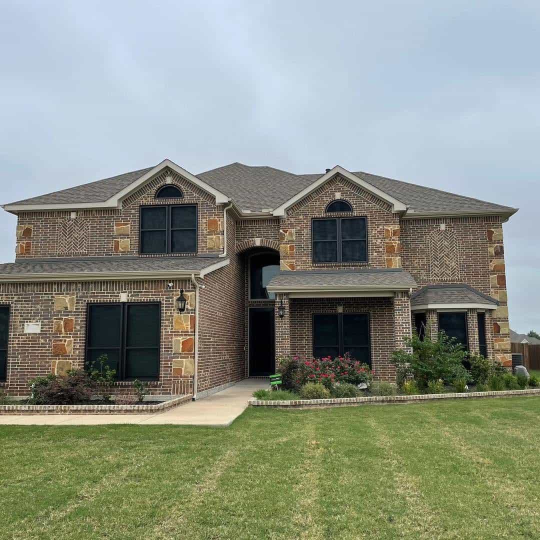 Two-story Texas brick home equipped with custom black security window screens in Southlake TX by Security Screen Masters of Texas