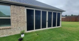 Multi-panel patio security screen system installed on brick home in Fort Worth TX by Security Screen Masters of Texas