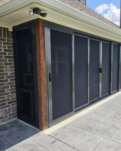 Patio security screen enclosure with built-in pet door on stamped concrete in Dallas TX by Security Screen Masters of Texas