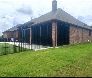 Backyard screened patio security enclosure with black pool fence in Southlake TX by Security Screen Masters of Texas