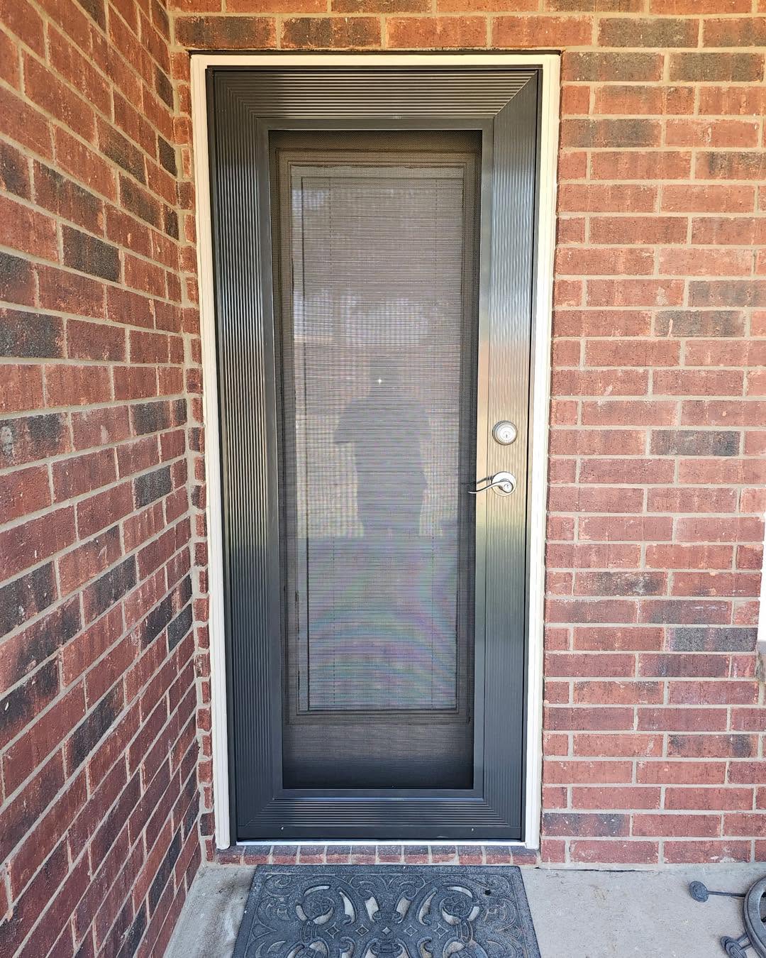 Bronze single security screen entry door installed on brick porch in Dallas TX by Security Screen Masters of Texas